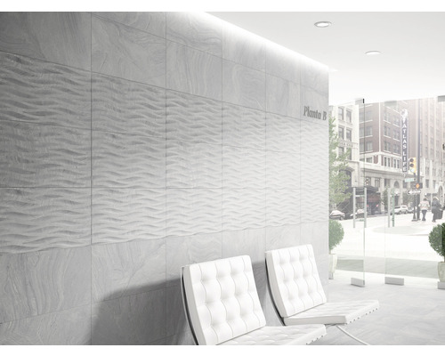 Väggdekoration med gråa plattor och vit sittplats inomhus.