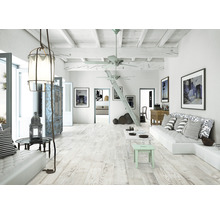 Ljust vardagsrum med trägolv, soffa, bord och dekoration