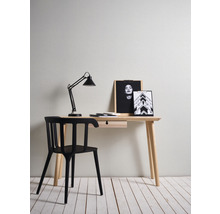 Skrivbord med svart stol, skrivbordslampa och fotoramar