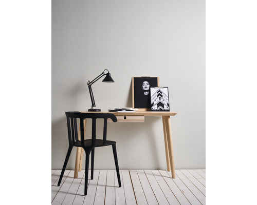 Skrivbord med svart stol, skrivbordslampa och fotoramar