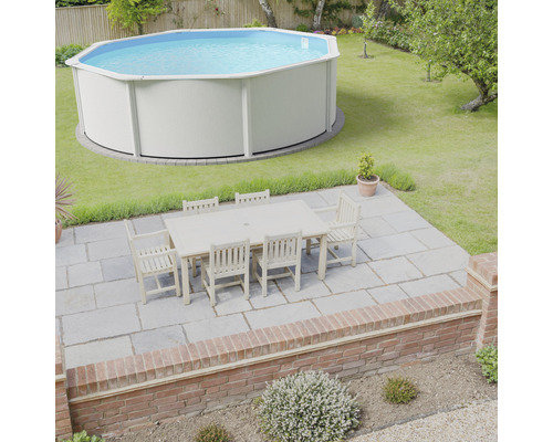 Trädgårdsscen med pool och trädgårdsmöbler på en terrass.