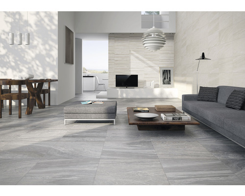 Ljust vardagsrum med moderna golvplattor, soffa och matbord