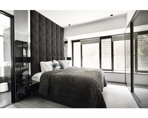 Ljust sovrum med säng, stoppad sänggavel och fönster