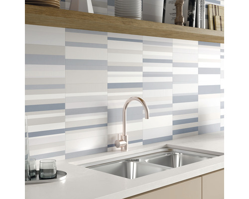 Köksscen med diskho, blandare och väggplattor med randigt mönster