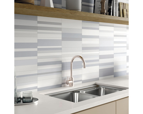 Köksscen med diskho, kran och väggplattor med randigt mönster