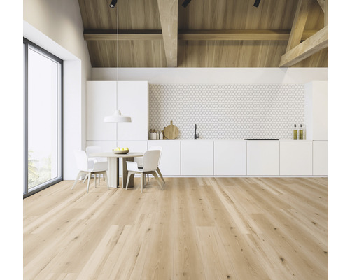 Ljust rum med takbjälkar i trä, trägolv och pentry