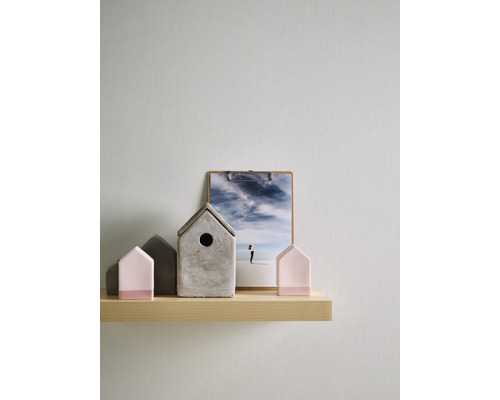 Dekorativa hus och ett fotografi på en trähylla.