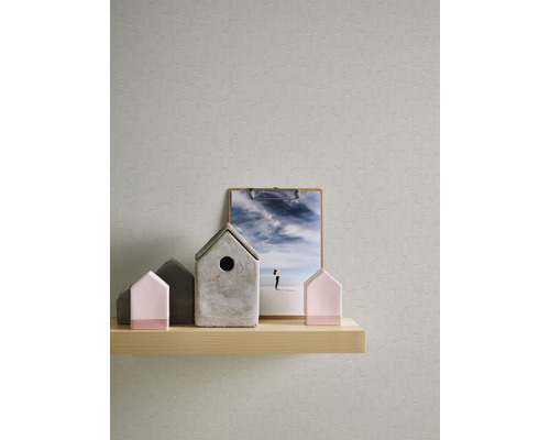 Dekorativa hus och en bild på en trähylla framför en tapet.