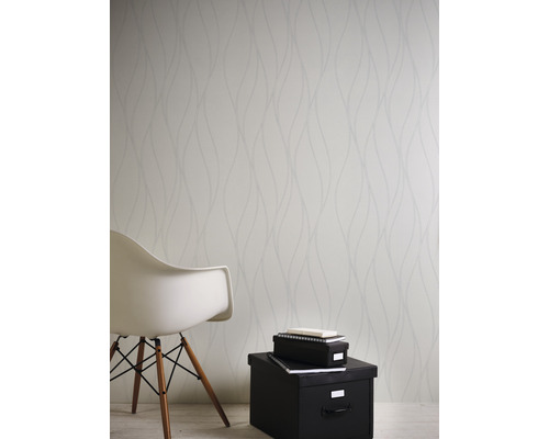 Ljust rum med mönstrad tapet, stol och förvaringslådor