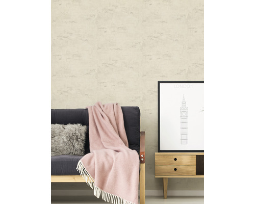 Vardagsrumsscen med ljusbeige strukturtapet, soffa, kudde, filt och byrå