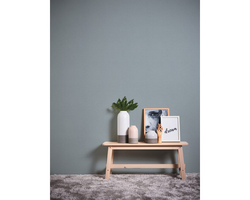 Dekorativ scen med bänk, vaser och tavlor på en vägg