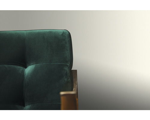 Detaljvy av en grön soffa med quiltat ryggstöd.