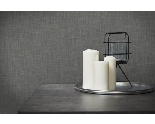 Dekorativ scen med ljus, ljusstake och grå strukturtapet