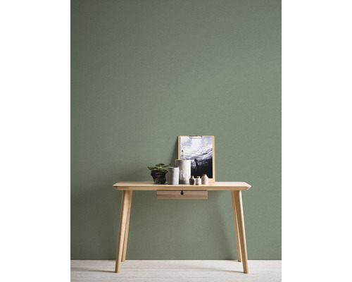 Träbord med dekoration framför en grön vägg