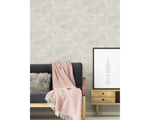 Scen med soffa, filt, kudde och mönstrad tapet för inredningsdesign