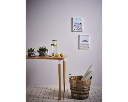 Ljus rumsinredning med bord, dekoration, bilder och korg