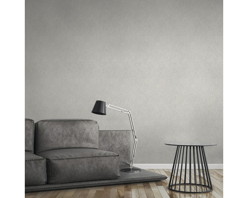 Vardagsrum med soffa, lampa, sidobord och mönstrad tapet