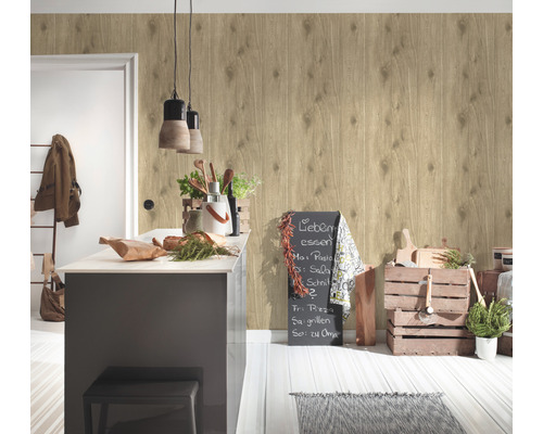 Ljus interiör med en väggtapet i träutseende, en köksö och dekorativa element.
