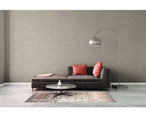 Vardagsrum med soffa, bord, golvlampa och mönstrad tapet