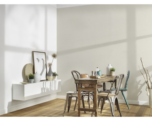 Ljust matrum med träbord, stolar och dekorativa element på väggen