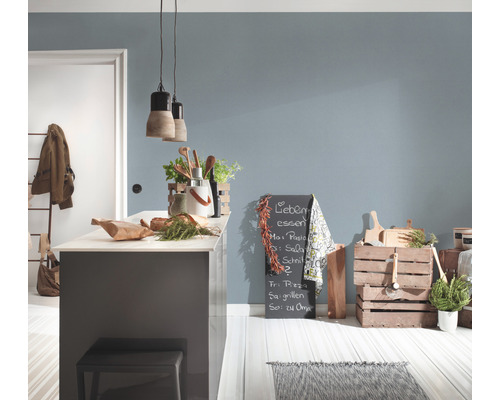 Ljust kök med köksö, dekorationer, griffeltavla och trälådor