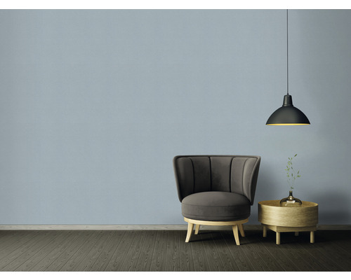 Vardagsrum med fåtölj, sidobord och hängande lampa