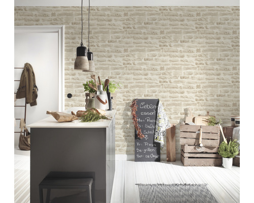 Ljust kök med köksö och väggtapet i stenlook för en vänlig atmosfär.