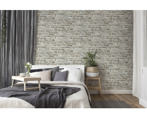 Ljust sovrum med stenmurstapet och säng