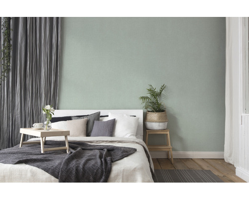 Sovrum med säng, sängbord, gardiner och krukväxt för en mysig atmosfär