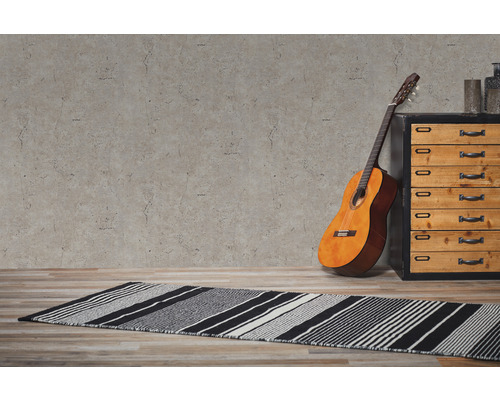 Miljöbild med gitarr, byrå och randig matta