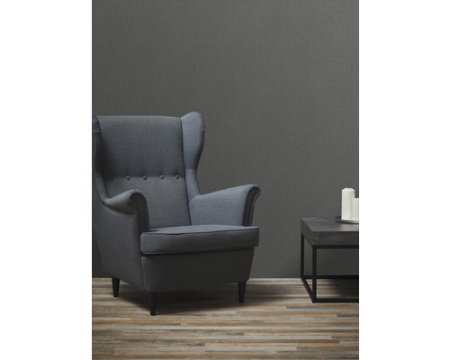 Vardagsrum med fåtölj, litet bord och tre ljus