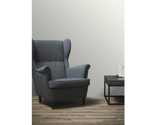 Vardagsrum med fåtölj och sidobord med ljus