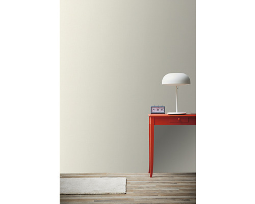 Miljöbild med väggfärg, bord, lampa, klocka och matta på trägolv