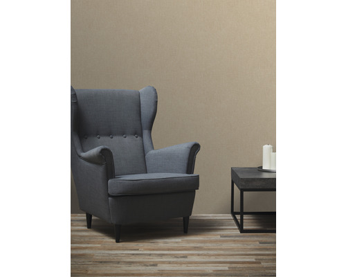 Vardagsrum med fåtölj, bord och tapet