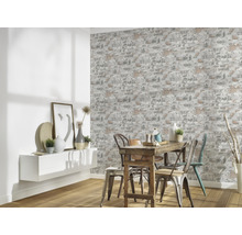 Matsal med väggtapet i tegelstensdesign, bord och stolar.