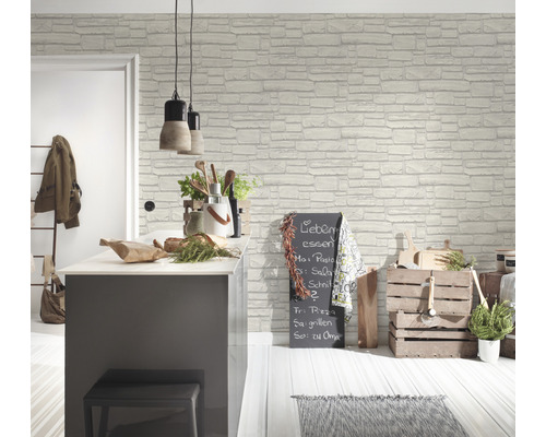Ljust kök med väggbeklädnad med tegelstensmotiv, köksö, hänglampor och dekorationer