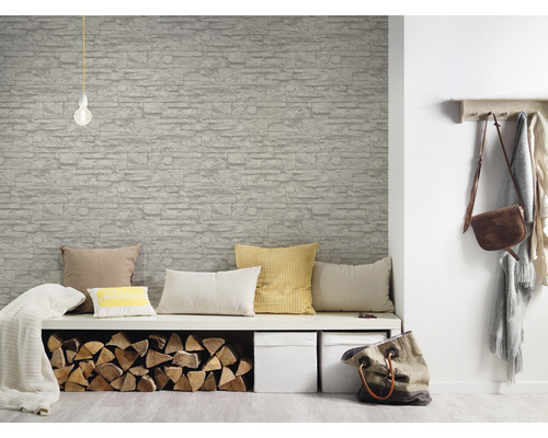 Vardagsrum med tapet i stenimitation, bänk, kuddar och vedträn
