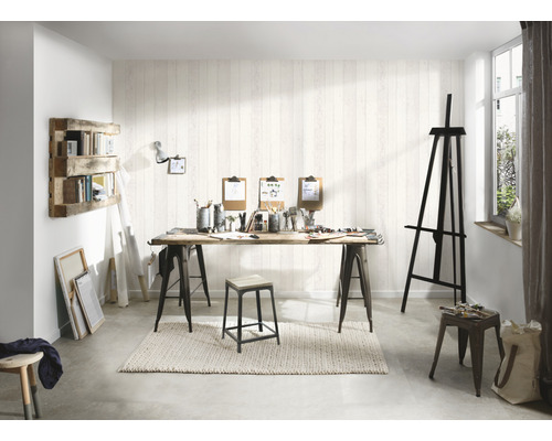 Ljus ateljé med staffli, bord med målningsmaterial och trähylla