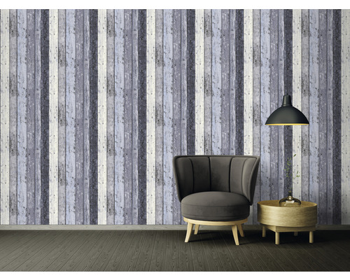 Vardagsrum med fåtölj, lampa och väggtapet med träutseende