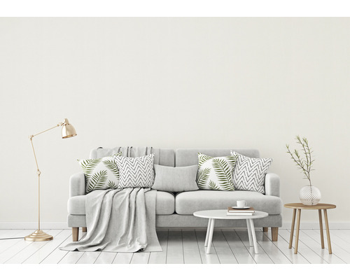 Vardagsrum med soffa, kuddar, bord och golvlampa