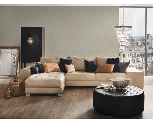 Vardagsrum med hörnsoffa, ottoman och dekorationer för en mysig atmosfär