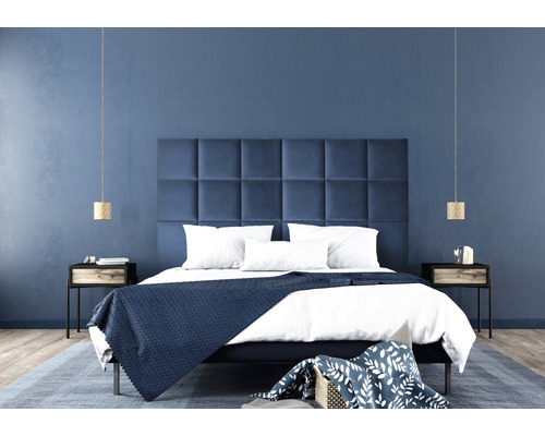 Sovrum med säng, vadderad sänggavel, två sängbord och pendellampor