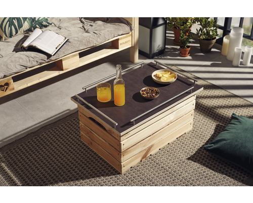 Uteplats med soffa av lastpallar och bord av trälådor, dekorerad med drycker och snacks