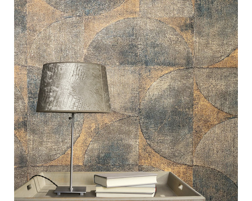 Närbild av en vägg med geometriskt tapetmönster och en lampa på ett bord