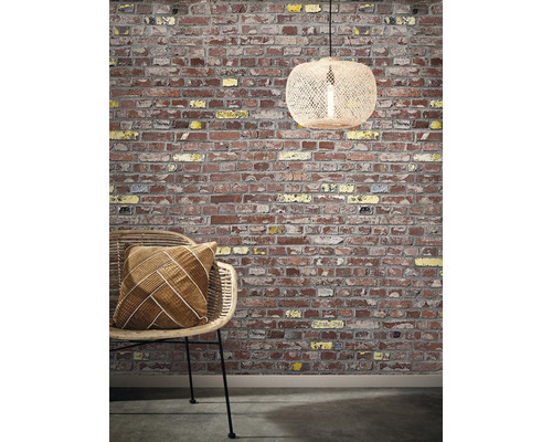 Dekorativ scen med en tegelvägg, en rottingstol med kudde och en hängande lampa
