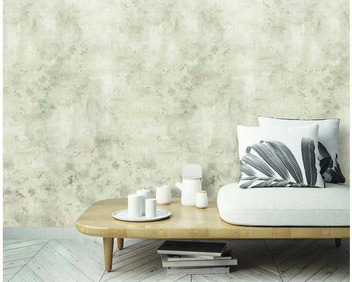 Scen med mönstrad tapet, soffa, kuddar och bord