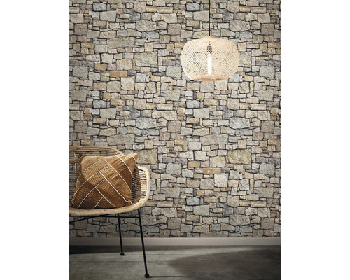 Dekorativ interiör med stenvägg, rottingfåtölj, kudde och hänglampa