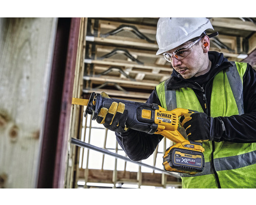 En byggnadsarbetare använder en DeWalt batteridriven tigersåg på en byggarbetsplats.