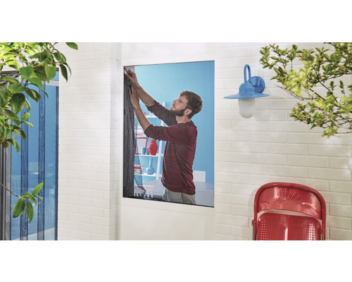 Man fäster insektsnät på ett fönster