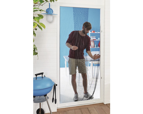 Man går genom en insektsdörr, grill i förgrunden